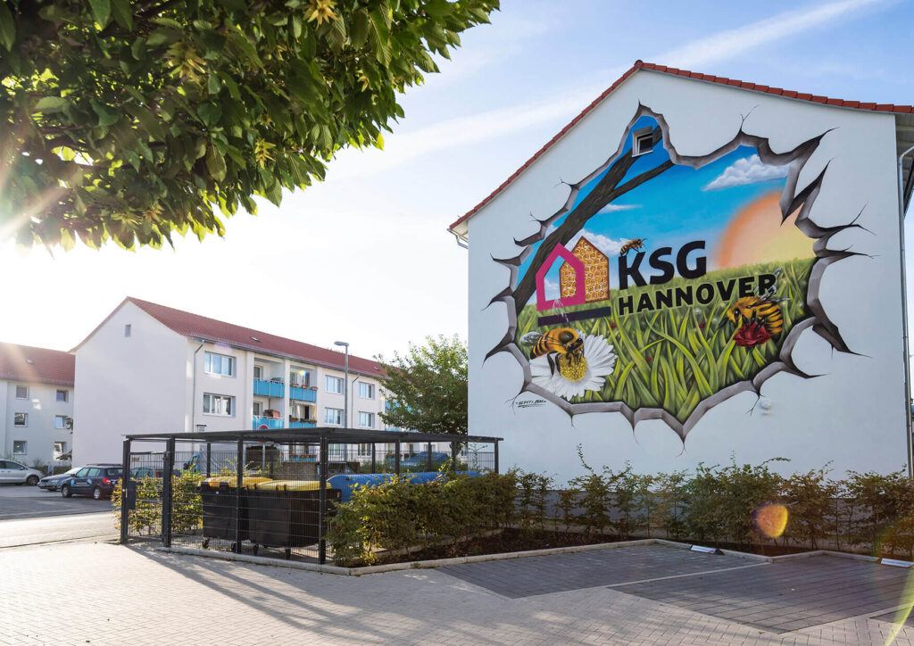 Graffiti Künstler Hannover erstellt Fassadengestaltung für KSG Mehrfamilienhaus mit Blüten und Tiefenwirkung
